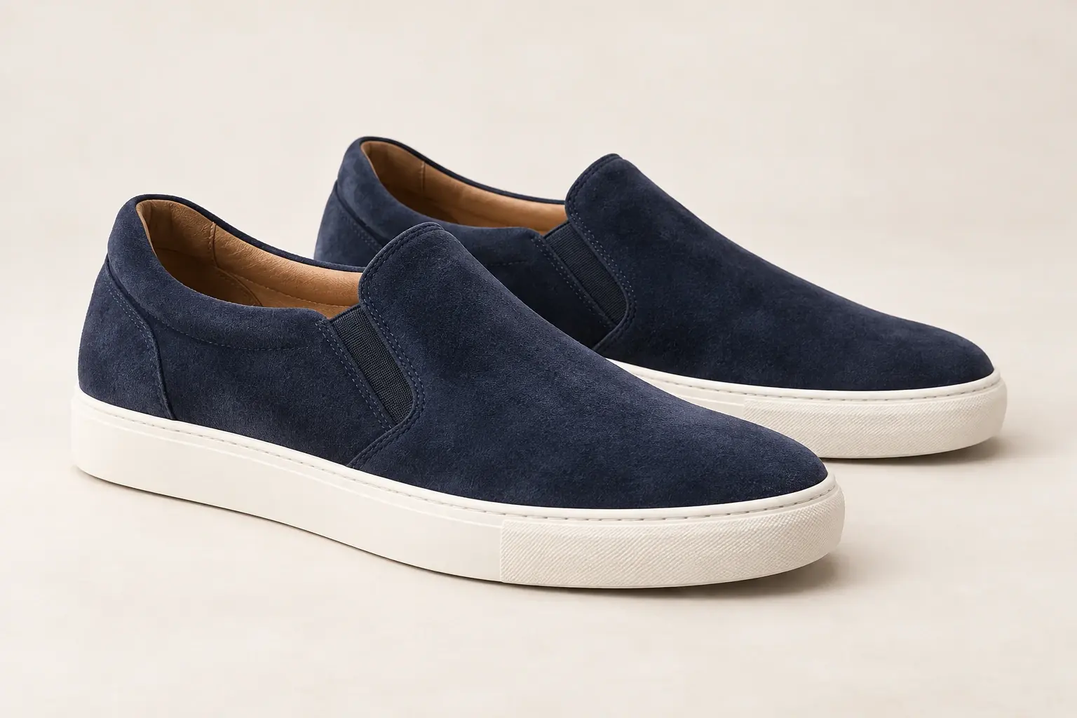 Ilustración mediante IA de unas zapatillas deportivas originales de ante azul marino con inserciones elásticas laterales y sin cordones.